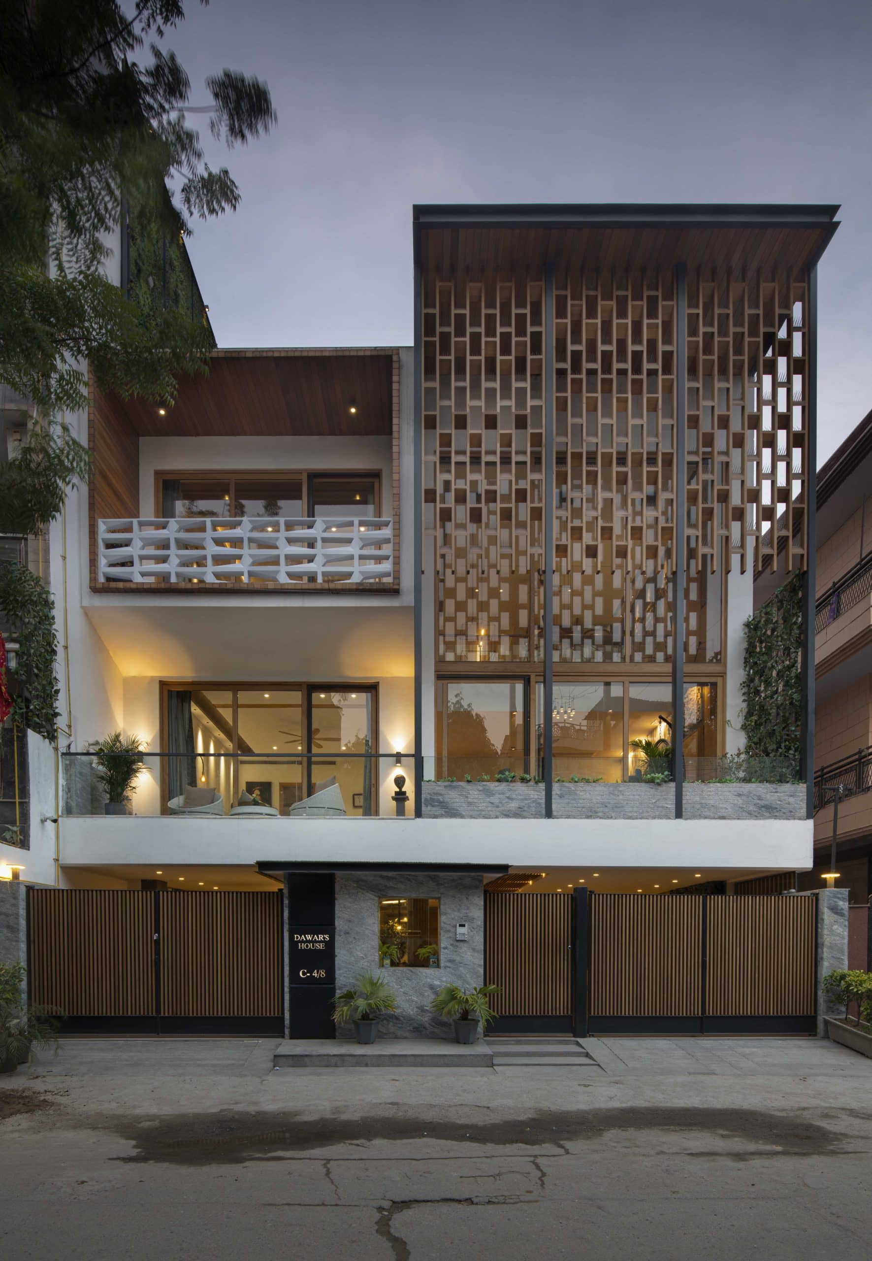 Exterior photography of modern façade/house with screen like panels ; sunset mode frontal street view.