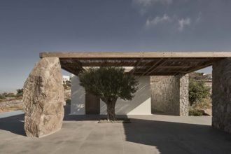 Exterior photography of entrance to a minimalist house enriched with natural elements; day mode frontal street view.