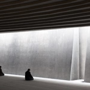 Interior photography of minimalist concrete mosque with concrete walls and gradual scaled ceiling with linear skylight.